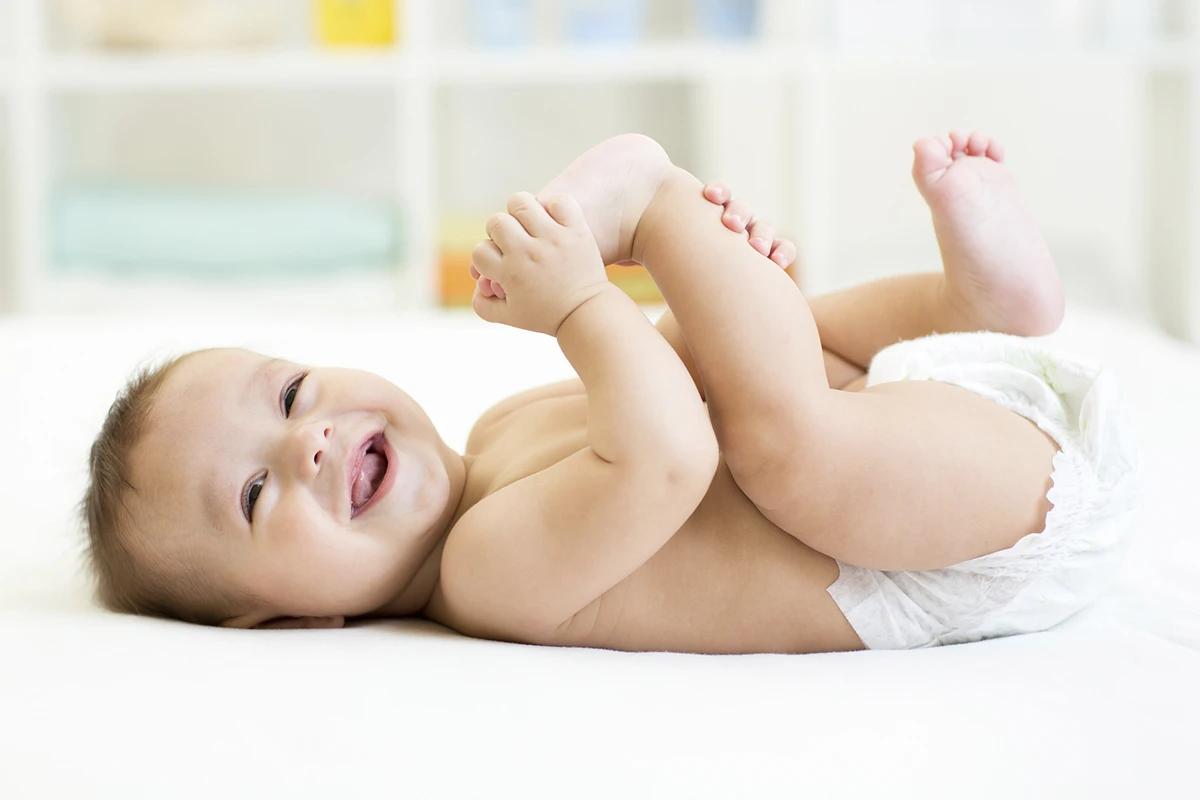 Bebê de fralda deitado na cama