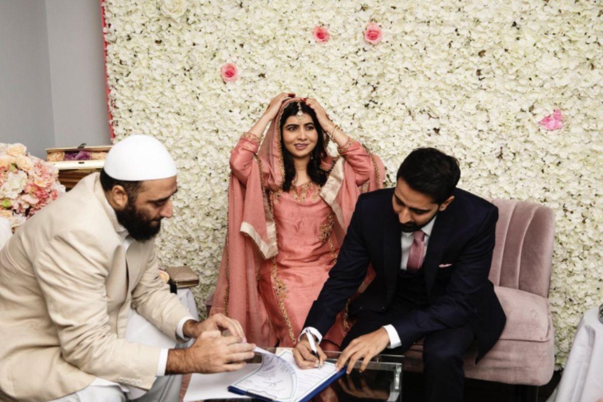 Malala e Asser assinando os documentos do casamento