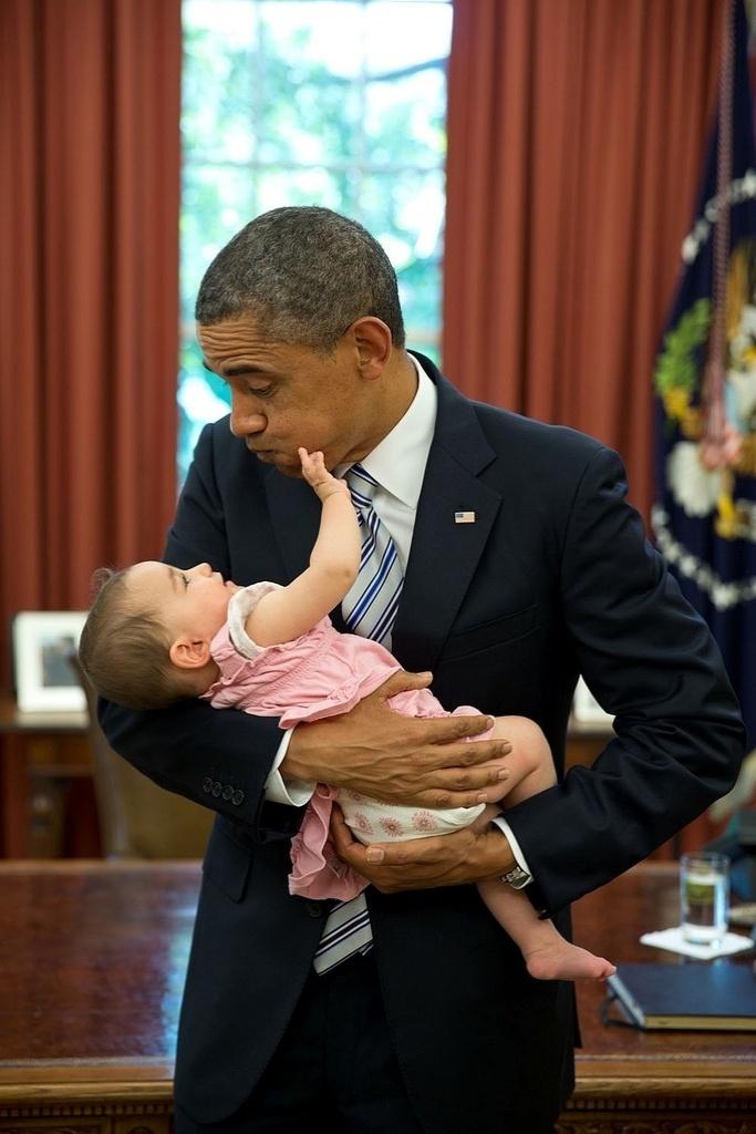 14jun2013---bebe-agarra-o-rosto-de-obama-em-foto-no-salao-oval-da-casa-branca-a-crianca-e-filha-de-uma-ex(1)
