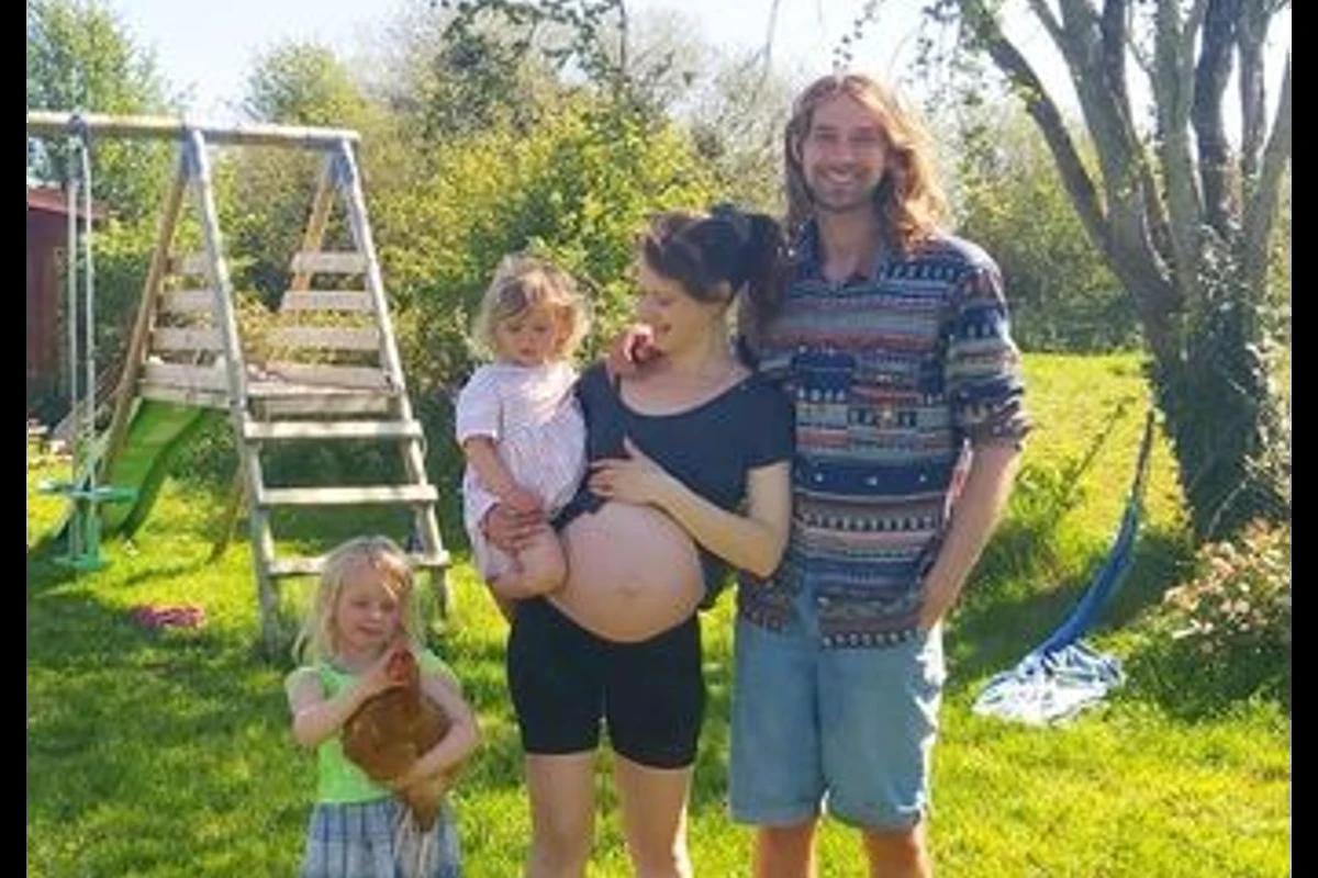 Pai,mãe grávida e filhos no campo