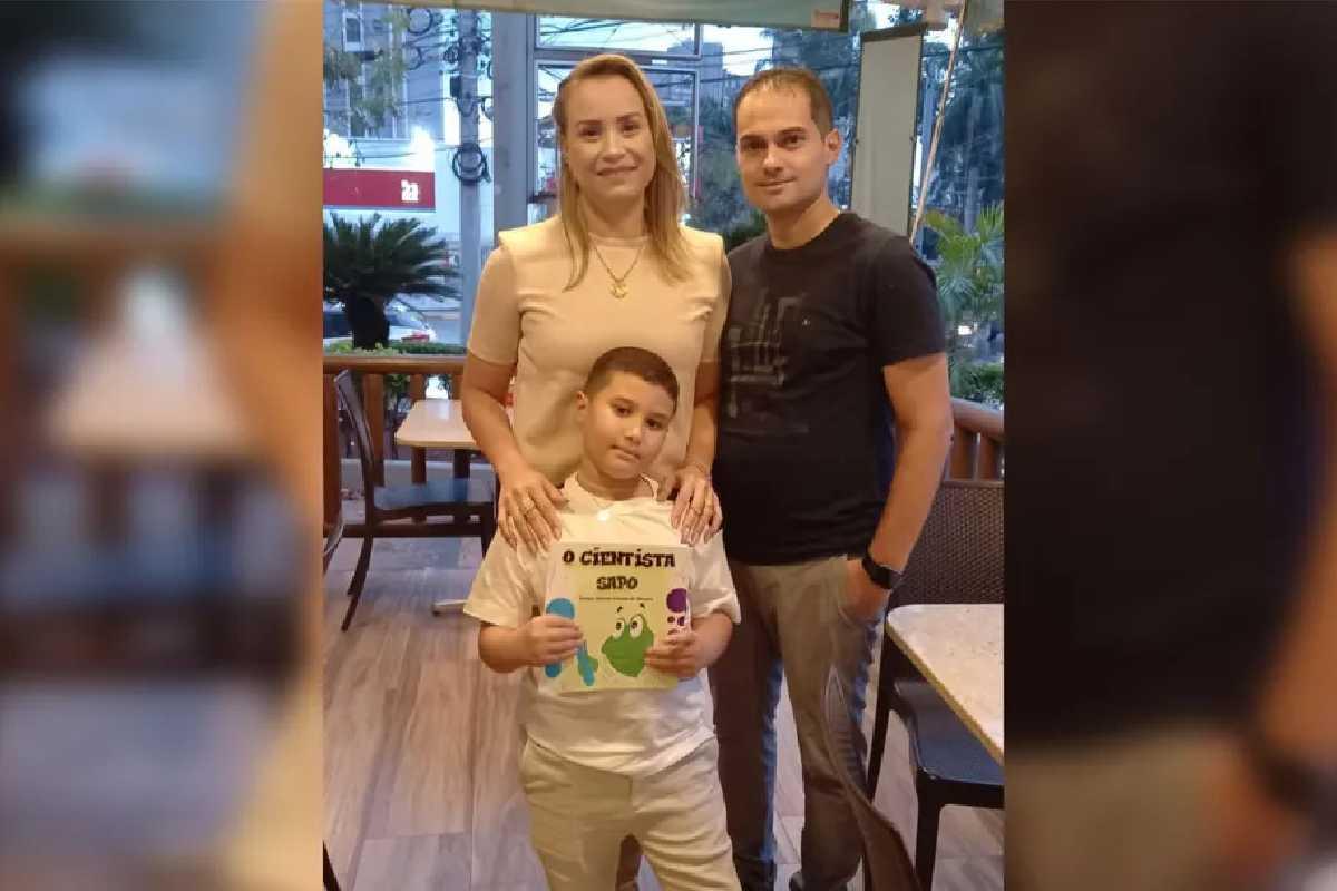 Menino com pais segurando um livro