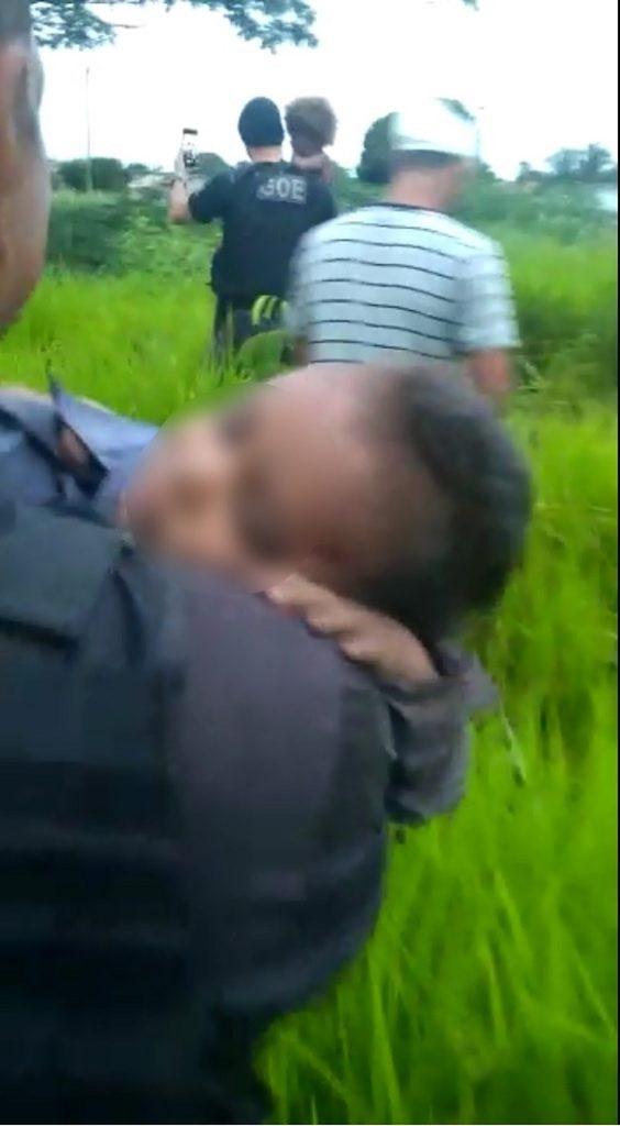 Policial segurando um dos irmãos | Foto: Reprodução / G1 / Gerência de Operações Especiais (GOE)