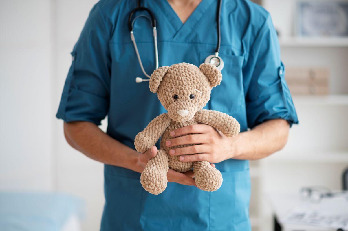 urso de pelúcia sendo segurado por um médico