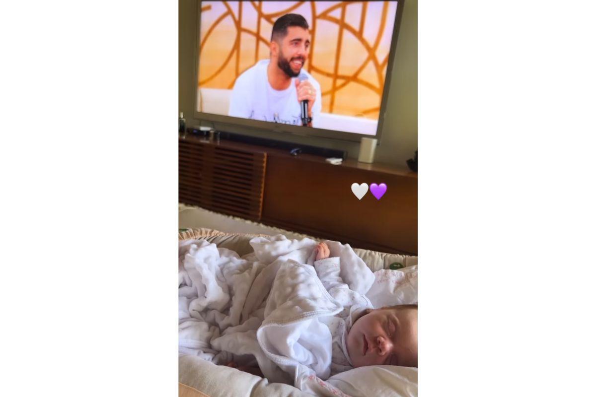 Criança dormindo com televisão ligada atrás