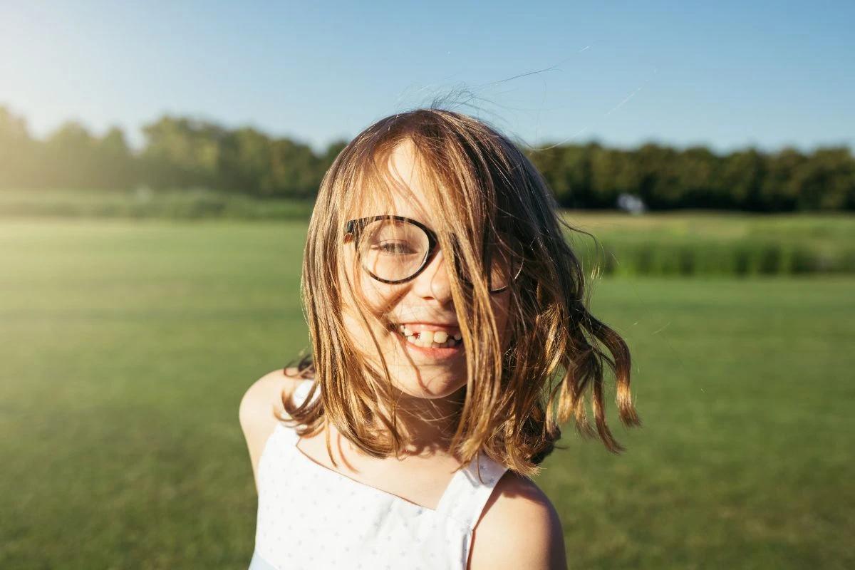 Menina com óculos sorrindo