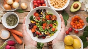 Salada variada em um fundo com diversos vegetais, representando a alimentação saudável