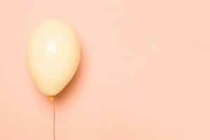 Balão rosa flutua em frente a um fundo da mesma cor representando o ganho de peso na gravidez.
