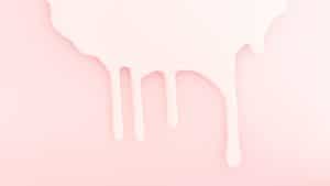 Leite derramado em um fundo rosa, representando a amamentação.