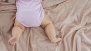 Bebê de barriga para baixo em uma cama.