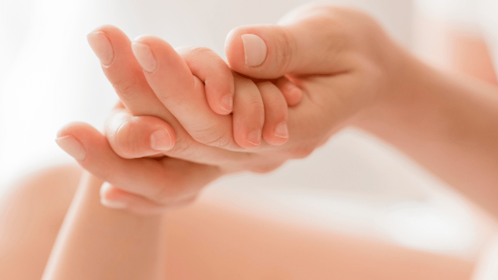 mão da mae segurando a mão do bebê