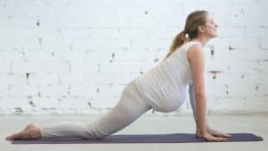 Mulher grávida em posição de yoga