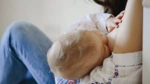 Mulher amamentando bebê com leite materno.