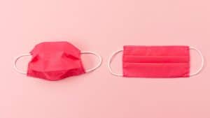 Máscaras vermelhas de resfriado em cima de um fundo rosa.