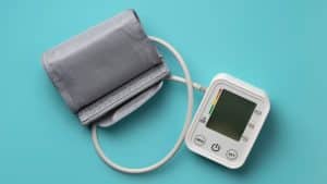 Medidor de pressão arterial em fundo azul, representando a pré-eclâmpsia na gravidez.