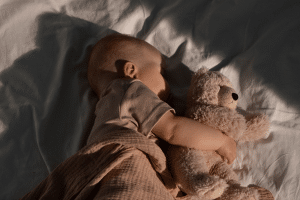Bebê dormindo com urso de pelúcia