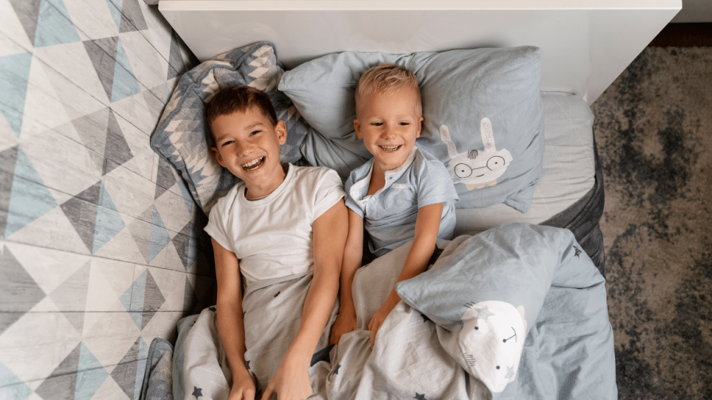 crianças na cama rindo