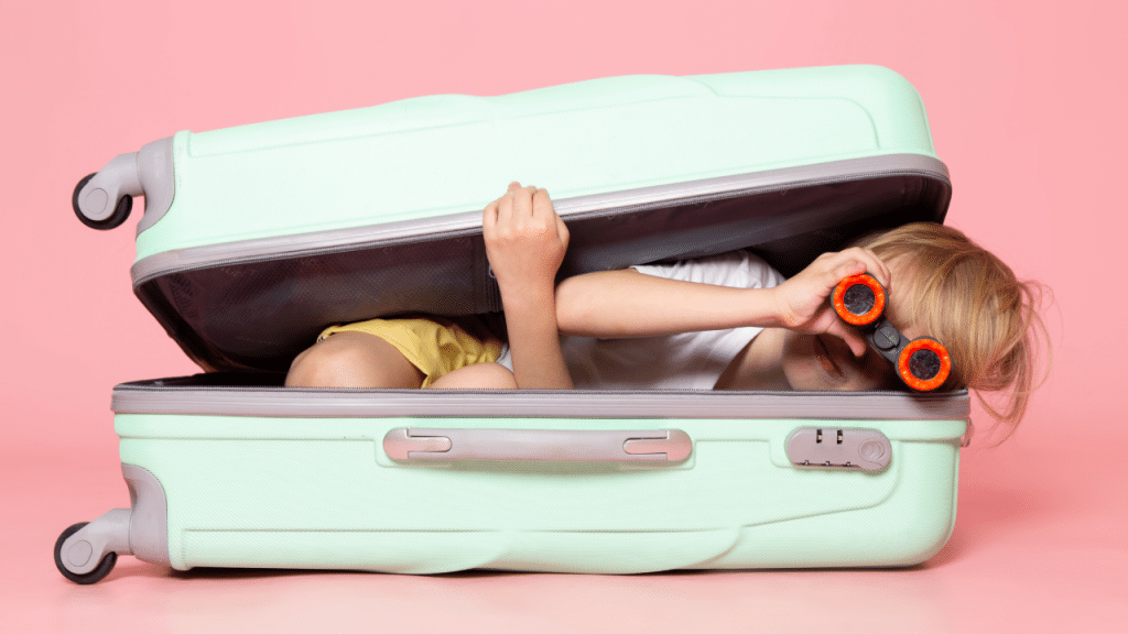 criança brincando dentro da mala