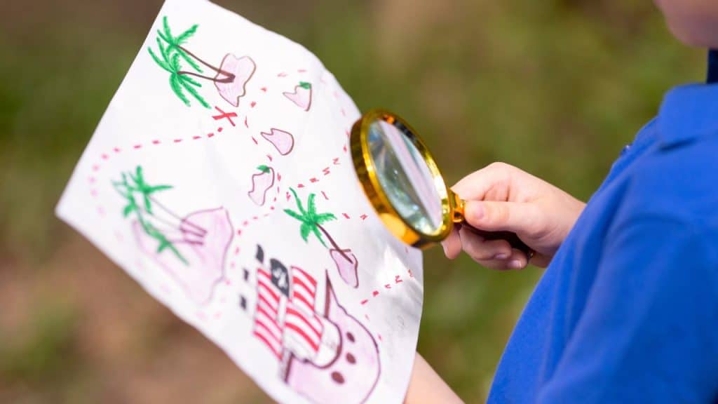 Menino brincando de caça ao tesouro, atividade que ajuda no desenvolvimento.