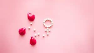 Símbolo feminino ao lado de pétalas de rosa, representando a progesterona na gravidez.