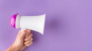 Megafone em um fundo roxo representando a comunicação infantil.