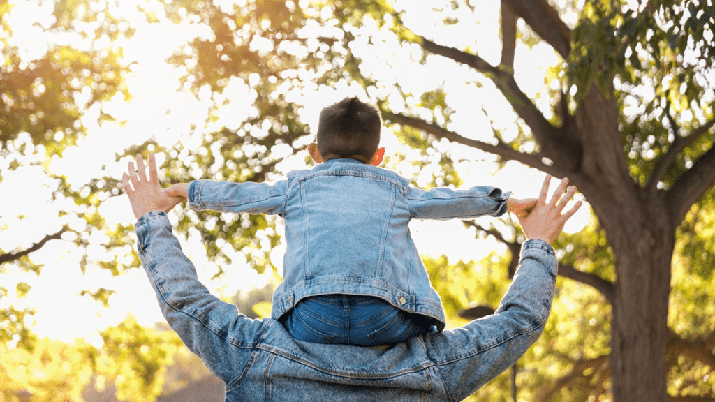Homem com uma criança nos ombros