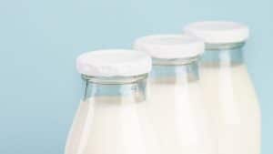 Garrafas de leite em um fundo azul.