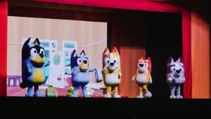 Personagens da série Bluey no palco de um teatro.
