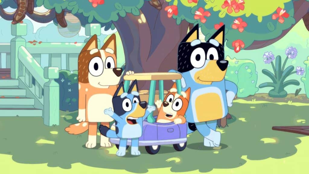 Bluey e sua família em um gramado com uma macieira e uma escada atrás.