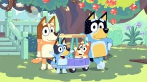 Bluey e sua família em um gramado com uma macieira e uma escada atrás.
