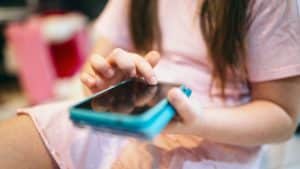 Menina usando um celular.