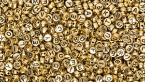 Miçangas douradas representando nomes de bebê.