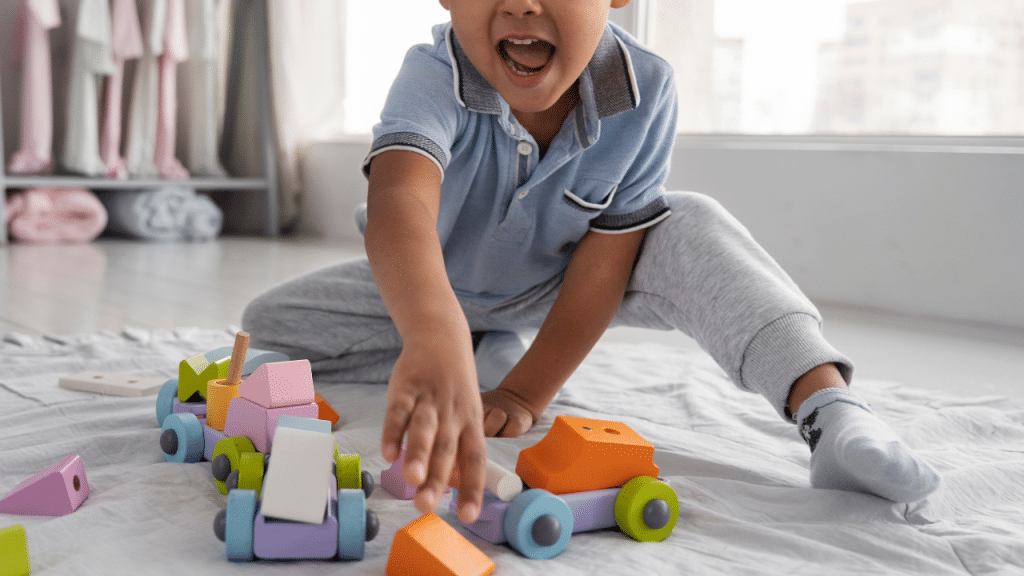 Criança sorrindo brincando c seus brinquedos