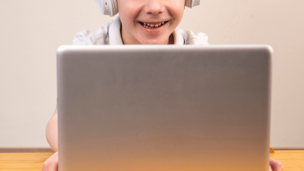 Criança olhando para o computador e sorrindo