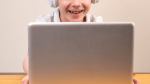 Criança olhando para o computador e sorrindo