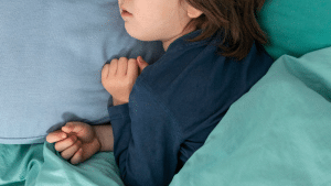 Crinaça dormindo, deitada em um lençol azul