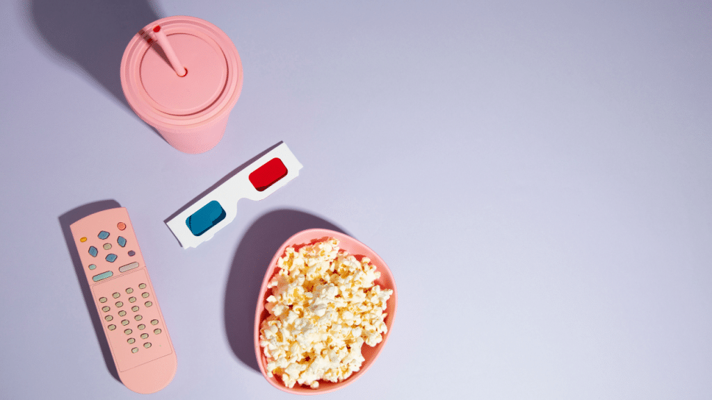 Um copo, uma pipoca e um fundo cinza