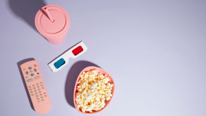 Um copo, uma pipoca e um fundo cinza