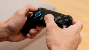 Uma mão segurando um controle de viedeogame preto