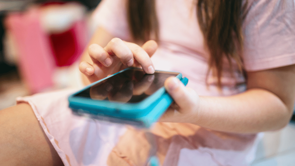 criança com um celular na mão com uma capinha azul