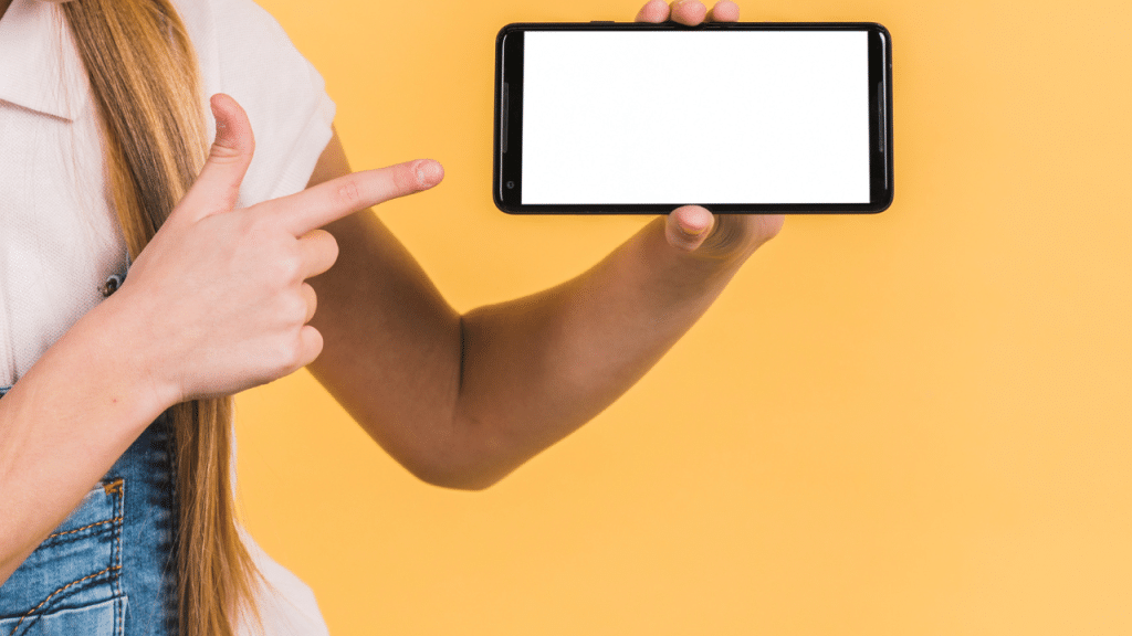 Uma mão segurando um celular em um fundo amarelo