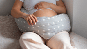 Barriga de uma mulher grávida, deitada com um travesseiro