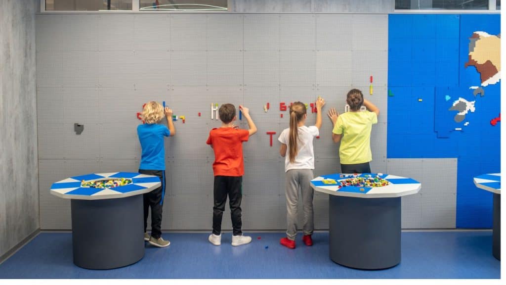 Crianças participando de atividade interativa em museu.