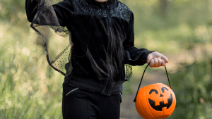 Mão de criança segurando uma abóbora em um campo