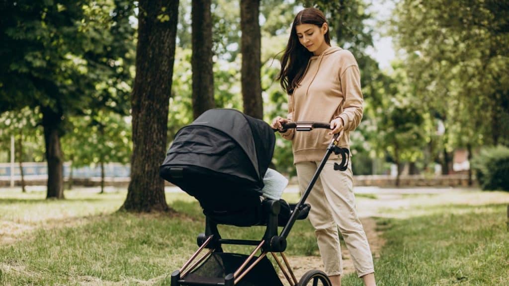 Mãe empurrando carrinho de bebê.