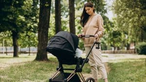 Mãe empurrando carrinho de bebê.