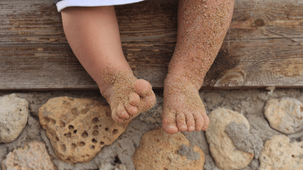 Pés de bebe sujo de areia