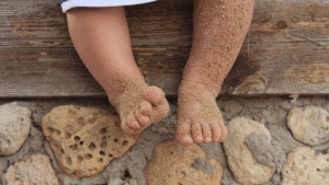 Pés de bebe sujo de areia