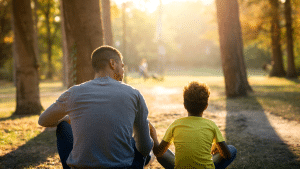 Pai e filha sentados conversando em um campo