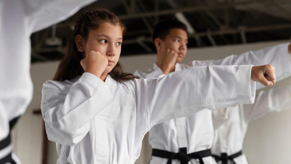 Menina praticando taekwondo como uma de suas atividades extras.