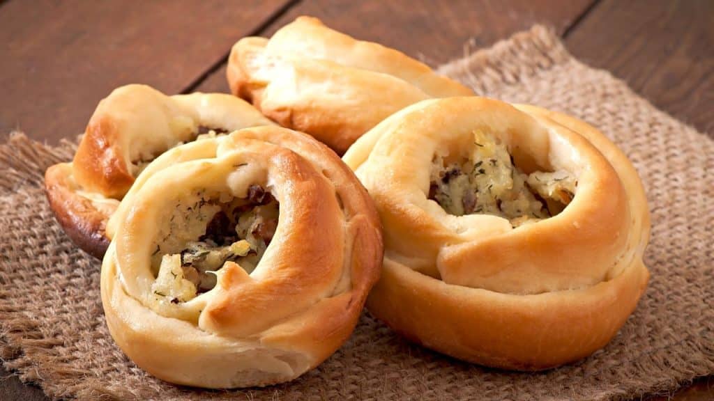 Esfiha aberta sobre uma superfície de madeira.